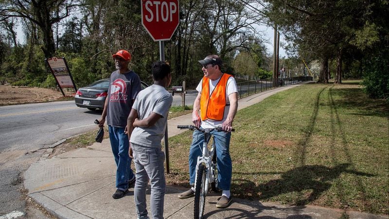 Bob Gilman (R) talks with his neighbors at the intersection of Bouldercrest Road and Cecilia Drive Southeast where a mother discovered her 3-year-old boy had been killed in a drive-by shooting Sunday night. STEVE SCHAEFER / SPECIAL TO THE AJC