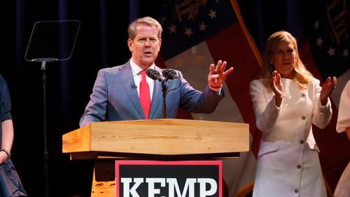 Gov. Brian Kemp says, “Four more years,” as he speaks to supporters after being re-elected at Coca-Cola Roxy at the Battery, Tuesday, November 8, 2022, in Atlanta.  Also shown is Marty Kemp, Brian’s wife.  (Jason Getz / Jason.Getz@ajc.com)