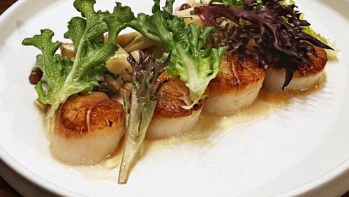 Scallops at Foundation Social Eatery in Alpharetta are served with pickled champagne grapes and foie gras chicken jus. Henri Hollis/henry.hollis@ajc.com