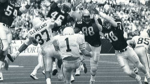 Georgia and Georgia Tech play on Dec. 2, 1989 in Atlanta, GA. Georgia punter Joey Hester gets a block from fullback Brian Cleveland, 37, as Tech rushers seem to fill the air. (AJC FILES/AP STAFF PHOTO BY CHARLES KELLY).