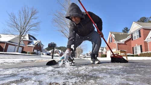 January 17, 2018 Snellville - Israel Hora tries to clear her driveway of ice with a garden trowel in Snellville on Wednesday, January 17, 2018. The snow has subsided, but the number of crashes has not. In Gwinnett County alone, police have worked at least 174 accidents since midnight. Some interstates are shut down, some roads are iced over and there's a strong chance they may remain too hazardous for travel all day. HYOSUB SHIN / HSHIN@AJC.COM
