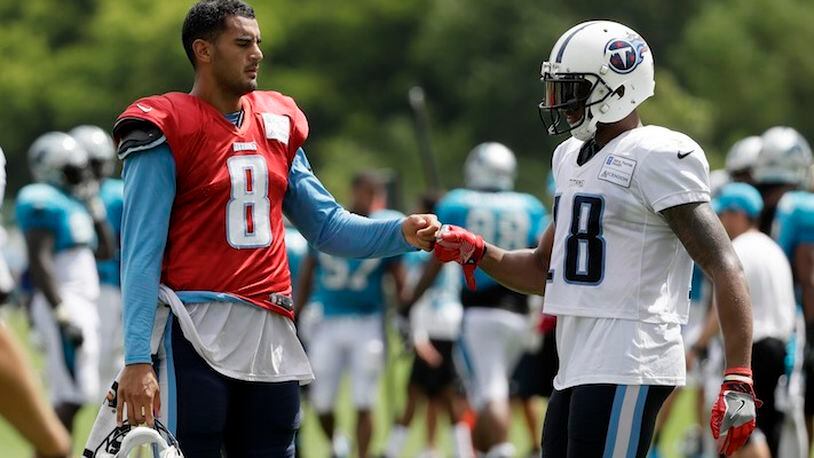 Tennessee Titans quarterback Marcus Mariota (8) bumps fists with wide receiver Rishard Matthews (18) after a play during a combined NFL football training camp with the Carolina Panthers Thursday, Aug. 17, 2017, in Nashville, Tenn. (AP Photo/Mark Humphrey)