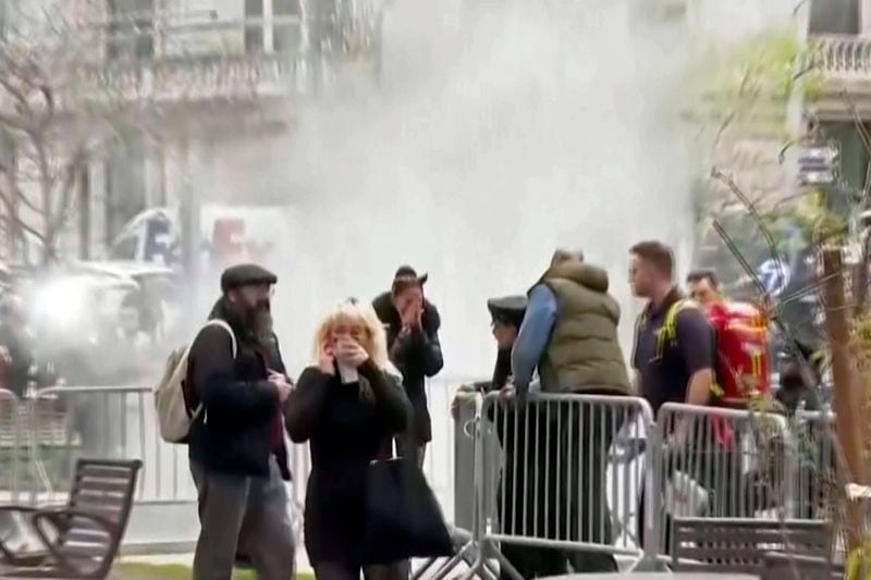 In this image taken from video, bystanders react after witnessing a man who lit himself on fire was extinguished, Friday, April 19, 2024, in a park outside Manhattan criminal court in New York. Emergency crews rushed away a person on a stretcher after the fire was extinguished outside the courthouse where jury selection was taking place in former President Donald Trump's hush money criminal case. (AP Photo)