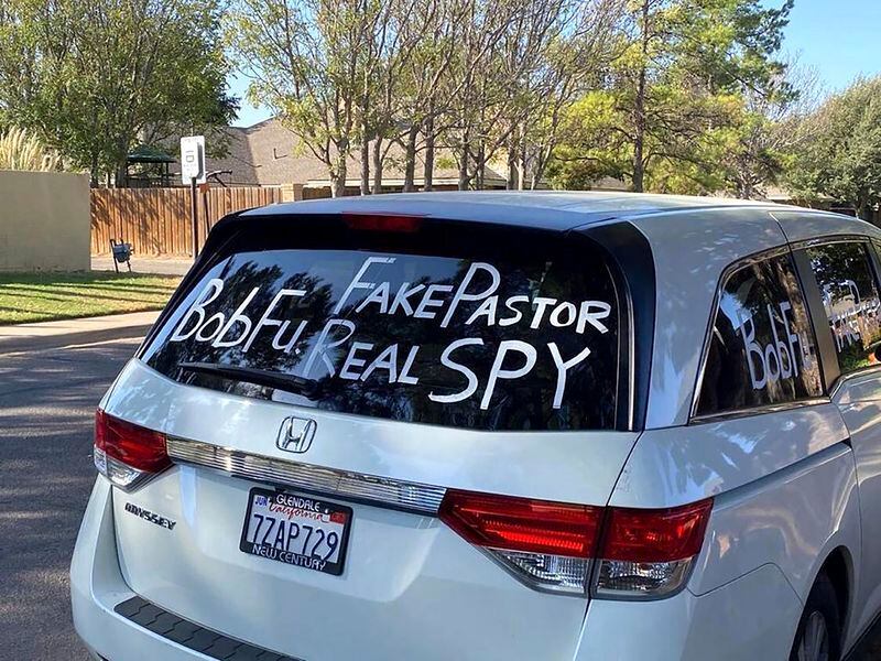 A van parked outside Bob Fu's home in Midland, Texas in the Fall of 2020, accuses the Chinese-American Christian pastor of being a spy for the Chinese Communist Party. American officials say foreign countries like Iran and China intimidate, harass and sometimes plot violence against political opponents and activists in the U.S. Fu, whose organization, ChinaAid, advocates for religious freedom in China, said he has endured far-ranging harassment campaigns for years. Large crowds arriving at his home by bus in well-coordinated actions he believes can be linked to the Chinese government. (Bob Fu via AP)