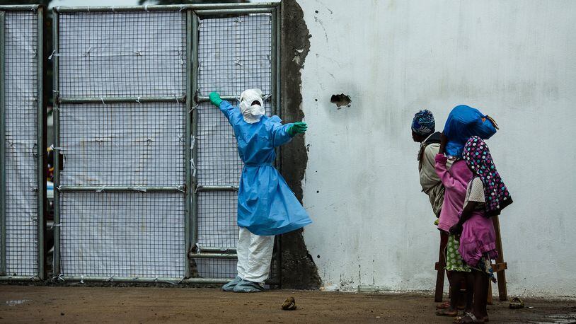 The David J. Sencer CDC Museum hosts a comprehensive exhibition featuring photographs, artifacts and documentation dedicated to the global health crisis of Ebola. In this image, a health care worker wearing protective garments opens the door for an ambulance exiting a Monrovia, Liberia, clinic. CONTRIBUTED BY MORGANA WINGARD, COURTESY OF USAID