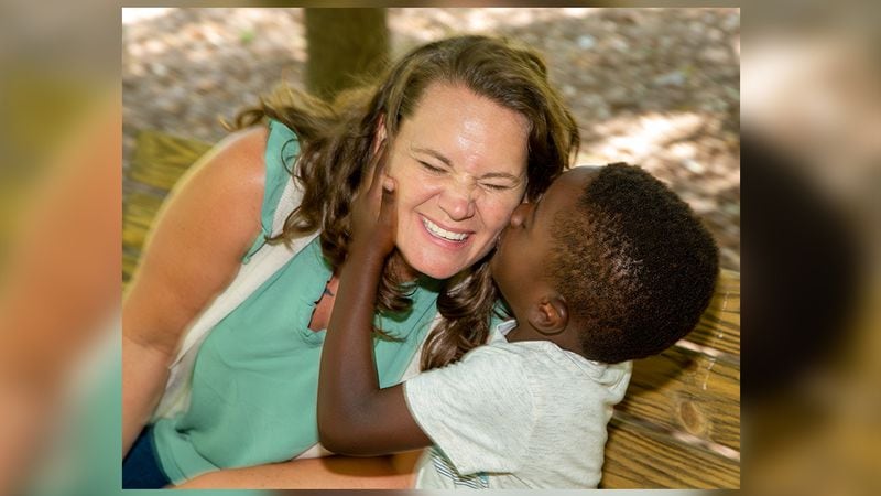 Single foster mom and adoptive mom, Amanda Vandalen, gets a kiss from Jeremiah, age 4, during an outing at Lake Avondale in Avondale Estates. She is also a social worker with the Gateway Center, a transitional shelter for the homeless on Prior Street in Atlanta. (Photo by Phil Skinner)