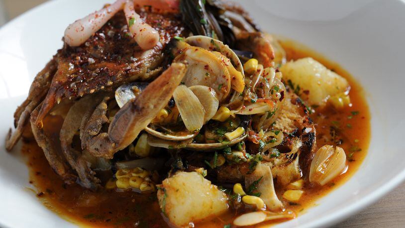 Soft shell crab cioppino featuring a garlicky tomato broth, potatoes, clams and corn at The Optimist.