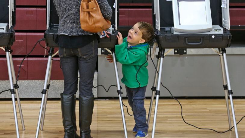 November 4, 2014 Atlanta: At Grady High School in Atlanta, Molly Goings cast her vote as her son, Harper-4 was in a playful mood Tuesday, Nov. 4, 2014. Atlanta voters hit the polls on Election Day with national implications in the U.S. Senate race and a deadlocked battle for governor. Voters reported much longer lines than usual Tuesday morning and sporadic problems across metro Atlanta. Georgia requires election winners to receive a majority of the vote - you’ll often hear politicos refer to this margin as “50 percent plus one (vote).” Several key races this fall have more than two candidates, making runoff elections possible. Georgia keeps separate election schedules for state and federal races. It is therefore possible to have runoffs on separate days: Dec. 2 for state and local races including governor, and Jan. 6 for federal races including the U.S. Senate. JOHN SPINK/JSPINK@AJC.COM November 4, 2014 At Grady High School in Atlanta, Molly Goings cast her vote as her son, Harper, 4, was in a playful mood AJC/John Spink