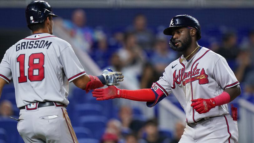 The Braves' Vaughn Grissom (18) congratulates Michael Harris after Harris scored on a sacrifice fly by Dansby Swanson during the sixth inning Friday against the host Marlins. (AP Photo/Wilfredo Lee)