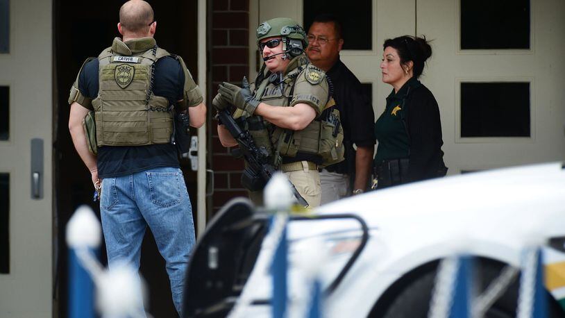 Marion County Police officers walk out a high school after a shooting there on April 20, 2018. In Georgia, Laurens County now plans to becomethe state’s first school district to authorize some teachers and others to carry guns on campus in hopes of preventing such incidents. (Photo by Gerardo Mora/Getty Images)