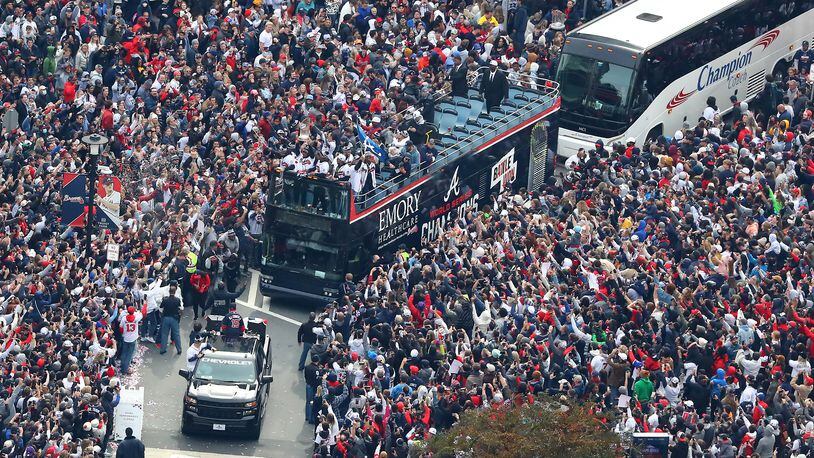 110521 ATLANTA: Braves players hoist the Commissioner's Trophy from the top of a double decker bus surrounded by thousands of fans as they arrive in the Battery outside Truist Park while the Atlanta Braves host a World Series Championship Parade and celebration on Friday, Nov. 5, 2021, in Atlanta.   “Curtis Compton / Curtis.Compton@ajc.com”