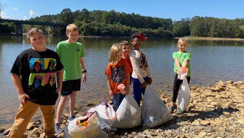 Cub Scouts with Pack 220 out of Kennesaw United Methodist Church show off some of the trash they pulled out of Lake Allatoona and from along its banks. From left are Henry Goodwin, Ethan Wren, Averie Monroe, James Wren, Kalen Turner and Norah Monroe. (Photo Courtesy of Joel Elliott/Marietta Daily Journal)