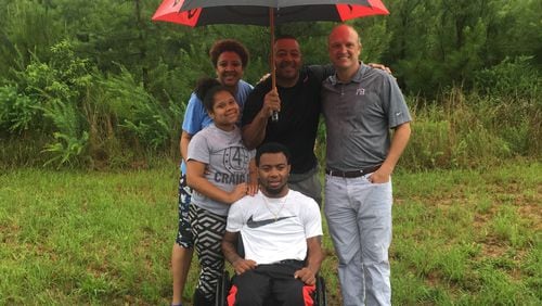 At the Jackson County lot chosen as the site for his new home, Devon Gales, center, is backed up by his sister, Teah, mother, Tish, father Donny and former Georgia linebacker Whit Marshall. (Photo courtesy Tish Gales)
