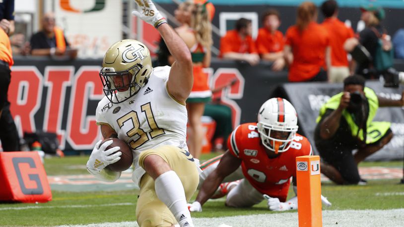 Georgia Tech running back Nathan Cottrell (31) scores against Miami defensive lineman Josh Neely (84) during the first half of an NCAA college football game, Saturday, Oct. 19, 2019, in Miami Gardens, Fla. (AP Photo/Wilfredo Lee)