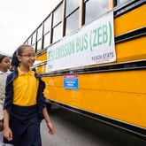 Natalie Bermejo leads other members of the Michelle Obama STEM Academy robotics club onto a new zero-emission school bus during a press conference announcing $400 million in grant funding for clean school buses for Clayton County public schools from the U.S. Environmental Protection Agency on Wednesday, May 17, 2023, at the Michelle Obama STEM Academy in Hampton, Georgia. The grants will fund the replacement of diesel school buses with zero-emission school buses. CHRISTINA MATACOTTA FOR THE ATLANTA JOURNAL-CONSTITUTION.