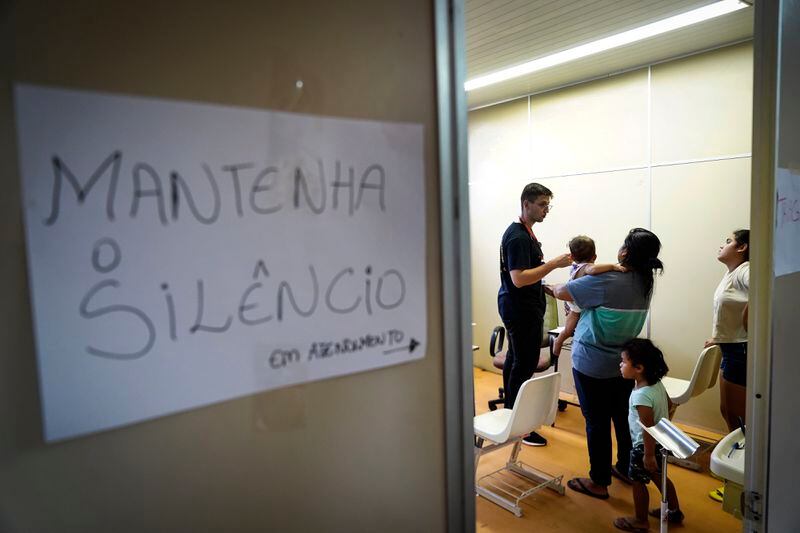 Residents visit a makeshift clinic for people whose homes were flooded by heavy rains, in Canoas, Rio Grande do Sul state, Brazil, Wednesday, May 8, 2024. (AP Photo/Carlos Macedo)