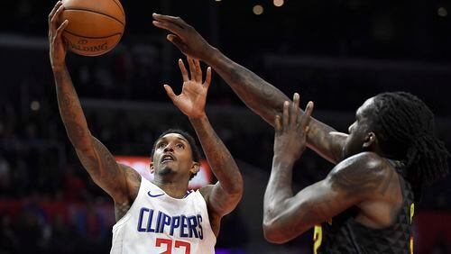Los Angeles Clippers guard Lou Williams, left, shoots as Atlanta Hawks forward Taurean Prince defends during the second half of a basketball game, Monday, Jan. 8, 2018, in Los Angeles. The Clippers won 108-107. (AP Photo/Mark J. Terrill)