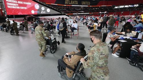 U.S. Army soldiers from Fort Stewart help some of the elderly through the process of getting their first vaccination at Mercedes-Benz Stadium, the state’s largest Community Vaccination Center on Wednesday, March 24, 2021 in Atlanta.  (Curtis Compton/Curtis.Compton@ajc.com)