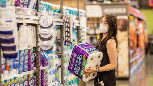 Alice Choe picks out paper goods on a full aisle in a Chamblee Kroger in September. An initial surge in buying and then heightened cleaning practices due to the coronavirus left paper towels in short supply from March to September. It took the industry about six months to catch up to demand. (Jenni Girtman for The Atlanta Journal-Constitution)