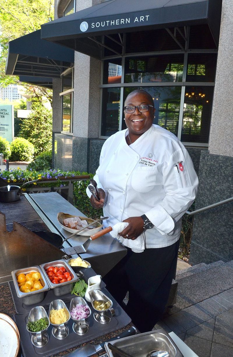 Chef Tonya Morris prepares to grill fresh cobia with black rice and sauteed tomatoes at the outdoor grill and seating area of Southern Art in Buckhead. Styling by Tonya Morris/ Contributed by Chris Hunt