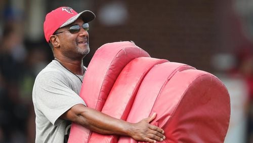 072816 FLOWERY BRANCH: Falcons special teams coordinator Keith Armstrong carrys some blocking pads out to the field for the first day of training camp on Thursday, July 28, 2016, in Flowery Branch. Curtis Compton /ccompton@ajc.com