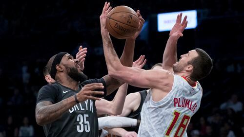 Brooklyn Nets forward Trevor Booker (35) and Atlanta Hawks center Miles Plumlee (18) battle for a rebound during the first half of an NBA basketball game, Saturday, Dec. 2, 2017, in New York. (AP Photo/Mary Altaffer)