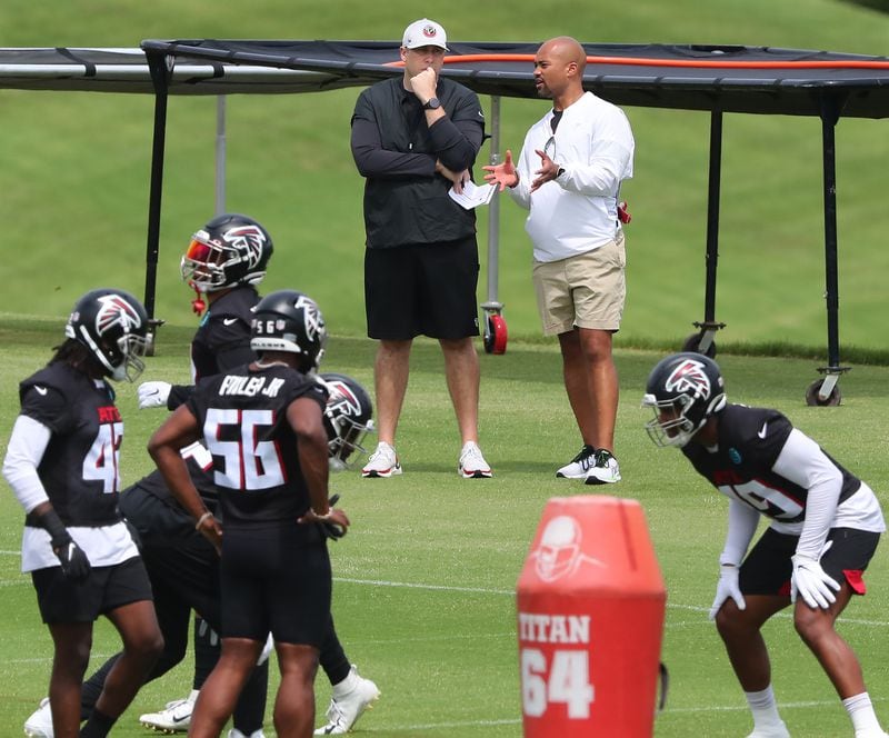 Falcons head coach Arthur Smith (top, left) and general manager Terry Fontenot (right) confer during team practice at minicamp Wednesday, June 10, 2021, in Flowery Branch. (Curtis Compton / Curtis.Compton@ajc.com)