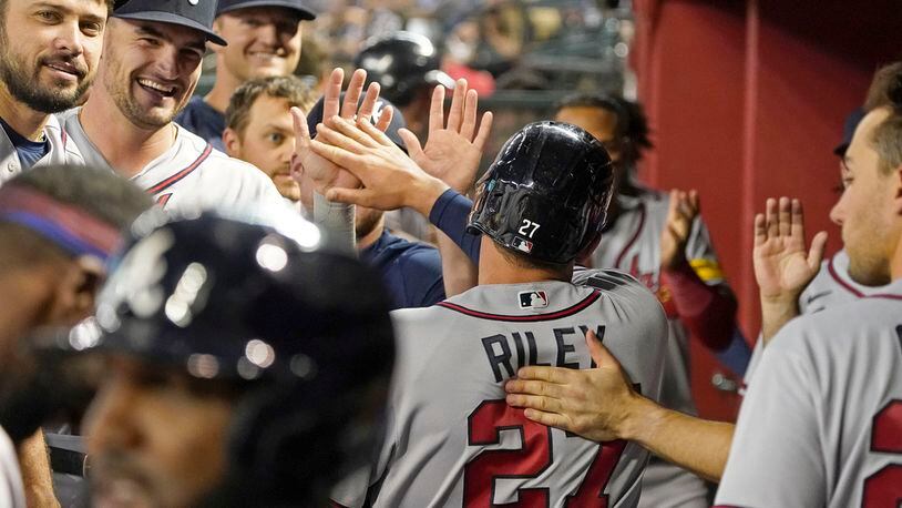 Atlanta Braves' Austin Riley is congratulated in the dugout after scoring against the Arizona Diamondbacks during the fifth inning of a baseball game Saturday, June 3, 2023, in Phoenix. (AP Photo/Darryl Webb)