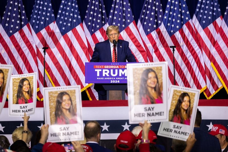 Republican presidential candidate and former president Donald Trump speaks about slain nursing student Laken Riley during a rally at Forum River Center in Rome on Saturday, March 9, 2024, as supporters hold up signs with her photo. (Arvin Temkar / arvin.temkar@ajc.com)