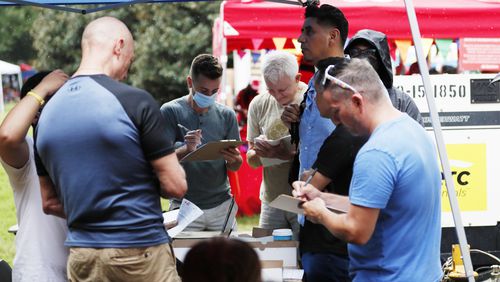 People fill out forms to obtain the monkeypox vaccine at the Department of Public Health tent during the 10th anniversary of the Pure Heat Community Festival at Piedmont Park on Sunday, September 4, 2022. (Photo: Miguel Martinez / miguel.martinezjimenez@ajc.com)