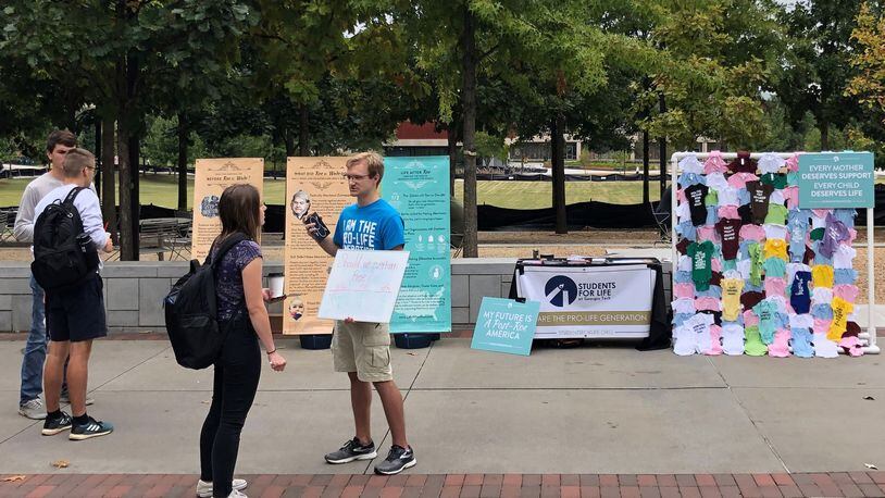 Students for Life President Brian Cochran discusses landmark abortion case Roe v. Wade with a fellow Georgia Tech student during a campus information event on Tech Walkway. CONTRIBUTED