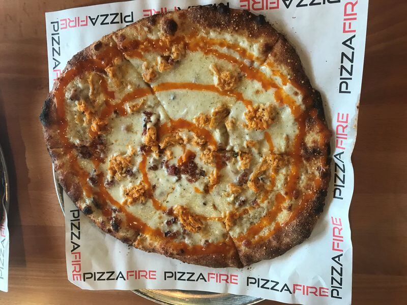 Our favorite pick at PizzaFire is the Buffalo. Toppings include free-range Buffalo chicken, mozzarella and Romano cheese on a ranch-bacon sauce. LIGAYA FIGUERAS / LFIGUERAS@AJC.COM