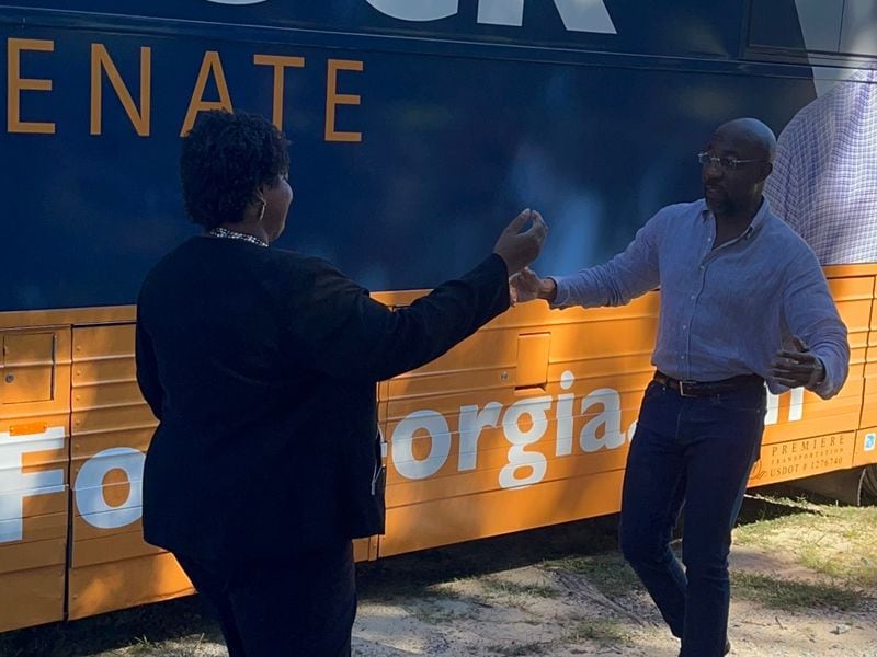 Democratic gubernatorial candidate Stacey Abrams and U.S. Sen. Raphael Warnock prepare to embrace Wednesday at a campaign event in Cobb County. 