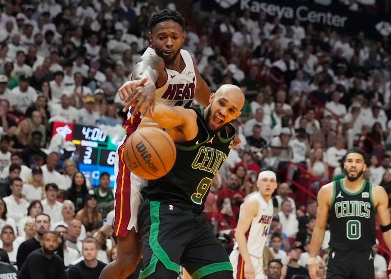 Boston Celtics guard Derrick White (9) and Miami Heat forward Haywood Highsmith, top, go after a rebound during the second half of Game 4 of an NBA basketball first-round playoff series, Monday, April 29, 2024, in Miami. (AP Photo/Marta Lavandier)