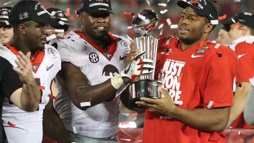 Sony Michel, Roquan Smith and Nick Chubb share the Rose Bowl trophy after beating Oklahoma 54-48 in a College Football Playoff Semifinal  on Monday.