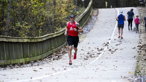 Dustin Biggerstaff trains at the Big Creek Greenway in Cumming. He spent 9 years in the Marine Corp and was medically discharged because of injury. He now raises money for a nonprofit that helped him, the Semper Fi and America’s Fund, through his athletic events. (Daniel Varnado/ For the Atlanta Journal-Constitution)
