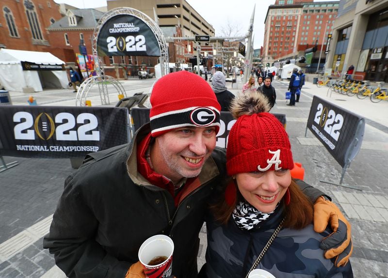 Rachel & Jared Shedd, Cumming, a couple divided by opposite allegiances, sport opposing head gear while taking in the festivities on Georgia Street on Saturday, Jan. 8, 2022, in Indianapolis.  “Curtis Compton / Curtis.Compton@ajc.com”`