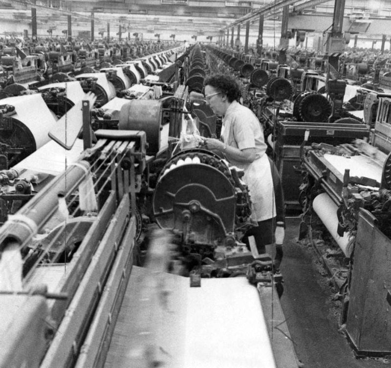 In subsequent decades, textiles shed more American jobs than any other industry. There were about 2.5 million U.S. textile workers in the early 1970s. That plummeted to less than half a million by 2017. Here, a textile worker inspects one of many rows of machines at an unidentified textile plant in Georgia in 1971.  (AJC Archive at GSU Library AJCP315-044j)
