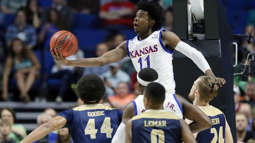 In this March 17, 2017, file photo, Kansas’s Josh Jackson (11) goes up for a shot over UC Davis’s Garrison Goode (44), Brynton Lemar (0) and Mikey Henn (24) in the first half of a first-round game in the men’s NCAA college basketball tournament in Tulsa, Okla. Jackson spent one season at Kansas and is expected to be a top-five pick in Thursday’s NBA draft. (AP Photo/Tony Gutierrez, File)