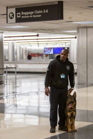 Clayton County Police's Antonio Kendrick waits  near the baggage claims with his K-9 Homer in the E Concourse. The U.S. Customs and Border Protection Office of Field Operations Port of Atlanta hosted a two-day K-9 training conference at Hartsfield-Jackson Atlanta International Airport (ATL). K-9 detection dogs from the U.S. Customs and Border Protection, Georgia Department of Correction, Georgia State Patrol, Union City, Newnan, Bowden Police and Clayton County Police participated in training exercises. PHIL SKINNER FOR THE ATLANTA JOURNAL-CONSTITUTION.