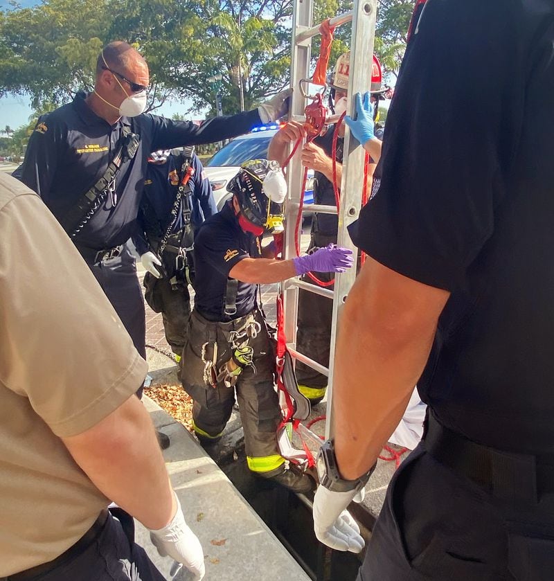 Delray Beach Fire Rescue remove a grate to access a storm drain and use a ladder and a harness to raise a trapped woman to ground level on Tuesday.