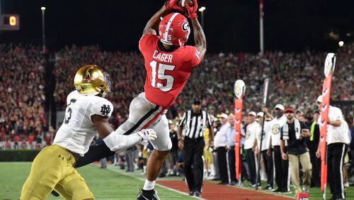 September 21, 2019 Athens - Georgia wide receiver Lawrence Cager (15) makes a touchdown pass over Notre Dame cornerback Troy Pride Jr. (5) in the second half  in a NCAA college football at Sanford Stadium in Athens on Saturday, September 21, 2019. Georgia defeated Notre Dame 23-17. (Hyosub Shin / Hyosub.Shin@ajc.com)
