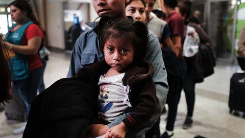 A Guatemalan father and his daughter arrive with dozens of other women, men and their children at a bus station following release from U.S. Customs and Border Protection on June 23, 2018, in McAllen, Texas. (Photo by Spencer Platt/Getty Images)