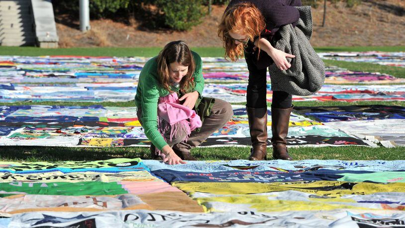 Kate Ogorzaly (left) and Meg Bertram stop for a closer look at the AIDS Memorial Quilt at Emory University’s McDonough Field. Members of an HIV/AIDS task force asked Fulton County for money and policy help to stop the spread of the disease. AJC FILE PHOTO