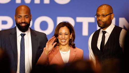 Earn Your Leisure podcast creators Troy Millings (left) and Rashad Bilal (right)  pose for a photo with Vice President Kamala Harris (center) during an event at the Georgia International Convention Center to kick off her economic tour focusing on improving opportunities for Black men on Monday, April 29, 2024. (Natrice Miller/ AJC)