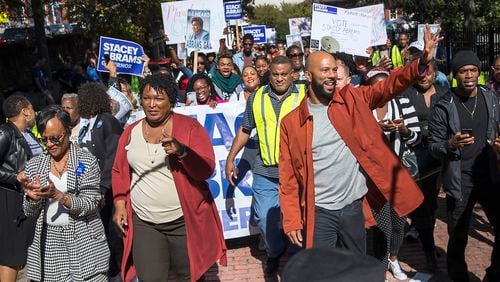 Georgia gubernatorial candidate Stacey Abrams, second from left, is joined by Grammy Award-winning rapper Common, right, attorney Glenda Hatchet and supporters during a Souls to the Polls rally and march in downtown Atlanta in October 2018. Legislation now under consideration in the General Assembly would place limits on weekend early voting that could deter counties from keeping polls open on Sundays. (ALYSSA POINTER/ALYSSA.POINTER@AJC.COM)