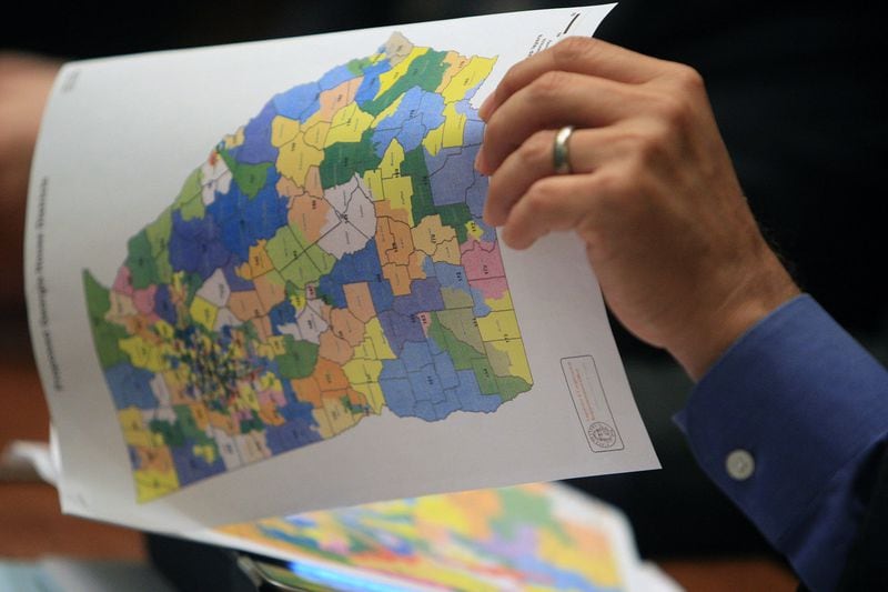 A lawmaker looks over maps during a redistricting debate in the General Assembly. AJC 2011 file photo