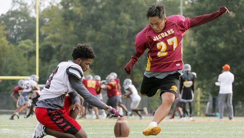 On the Maynard Jackson High School practice field, Jack Breedlove gets some kicks with his holder, Ayub Carswell. ( BOB ANDRES / BANDRES@AJC.COM)