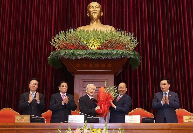 FILE - Vietnam Communist party General Secretary Nguyen Phu Trong, center left, is presented with a bouquet by Prime Minister Nguyen Xuan Phuc, center right, in Hanoi, Vietnam, Sunday, Jan. 31, 2021. Vietnamese state media outlet VN Express reports that the head of Vietnam’s Parliament, Vuong Dinh Hue, has resigned. He is the latest member of senior government to leave office amid an ongoing anti-corruption campaign. (Le Tri Dung/VNA via AP, File)