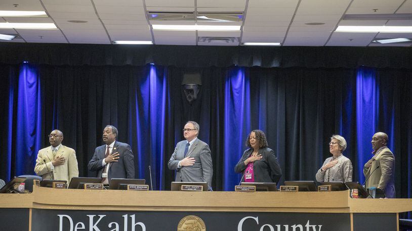 Members of the DeKalb Board of Commissioners stand for the Pledge of Allegiance before the start of a meeting on March 13. ALYSSA POINTER/ALYSSA.POINTER@AJC.COM